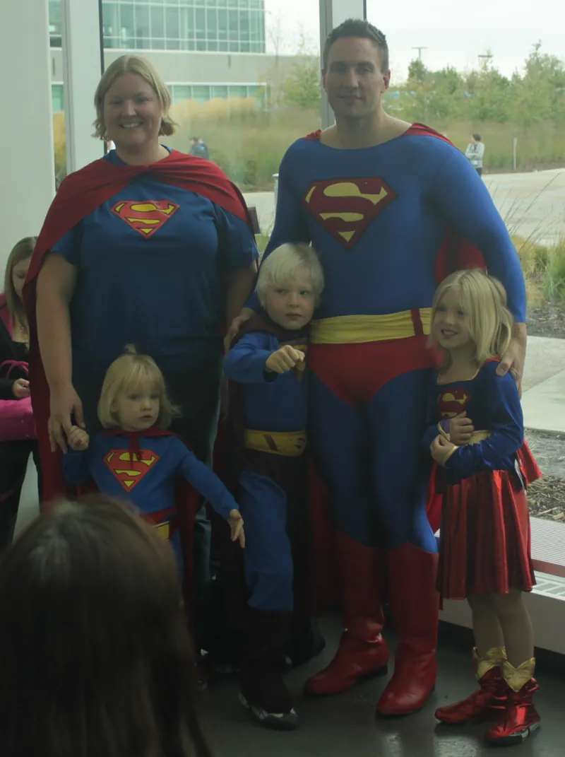 A family dressed as Superman characters at a comic convention